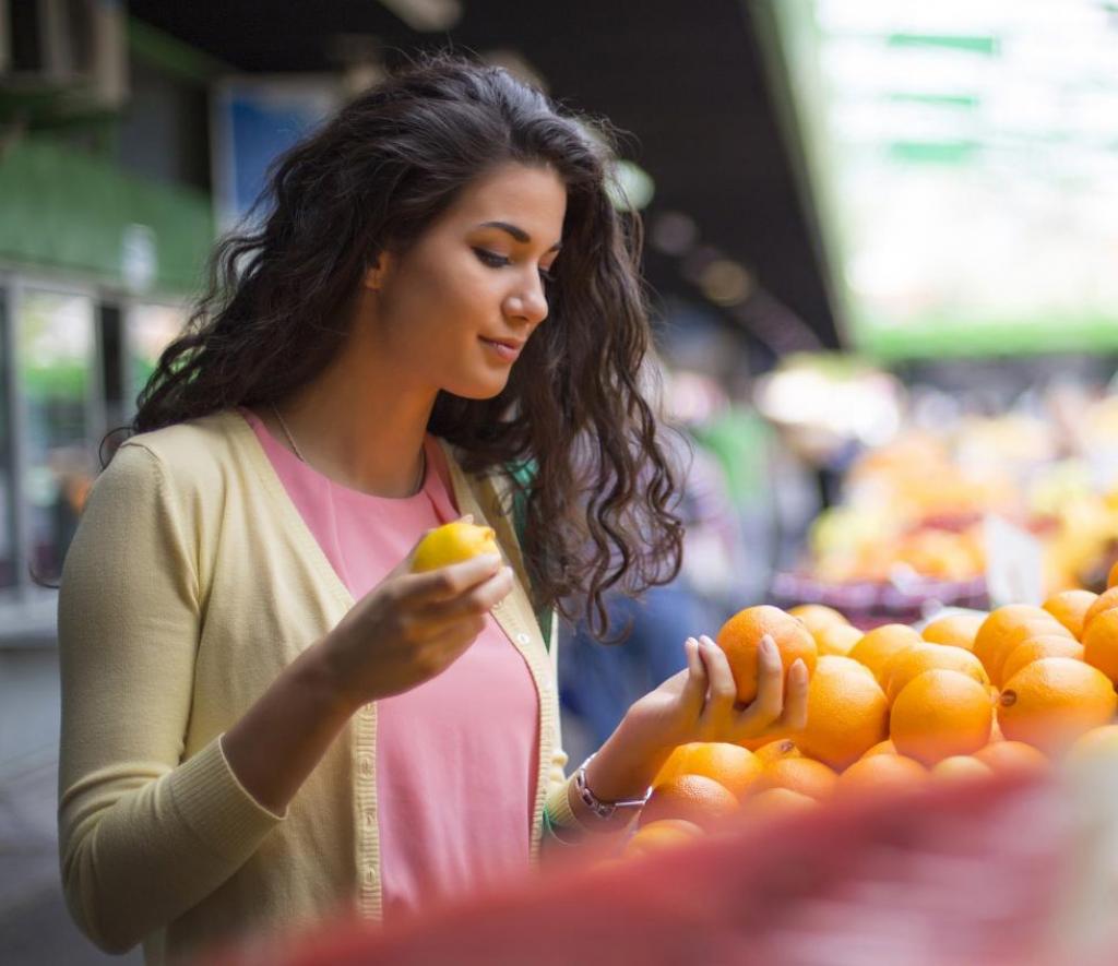 girl at market looking at oranges